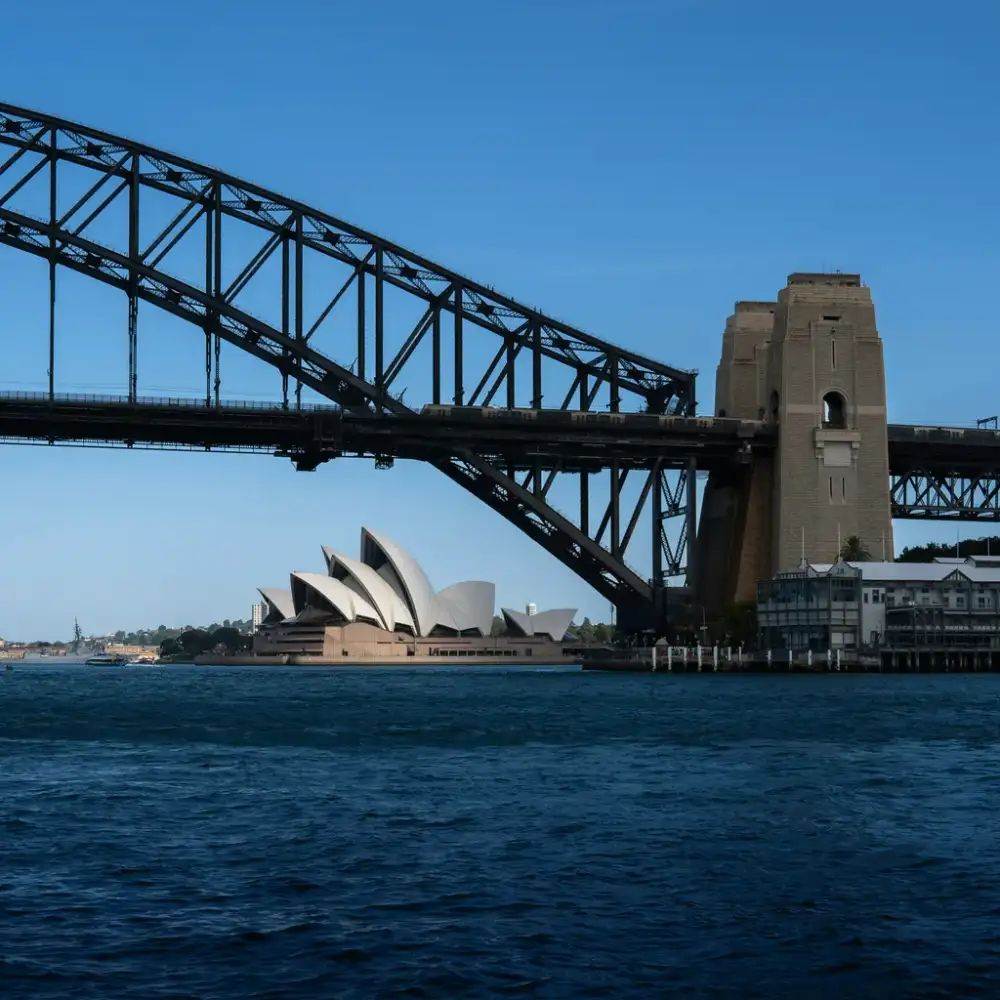 Sydney Harbour Bridge stretching across the water with the Opera House in the background